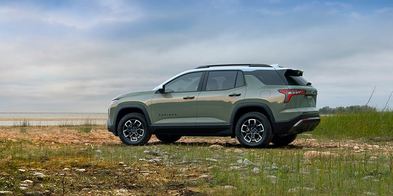A green suv sitting parked in the grass.