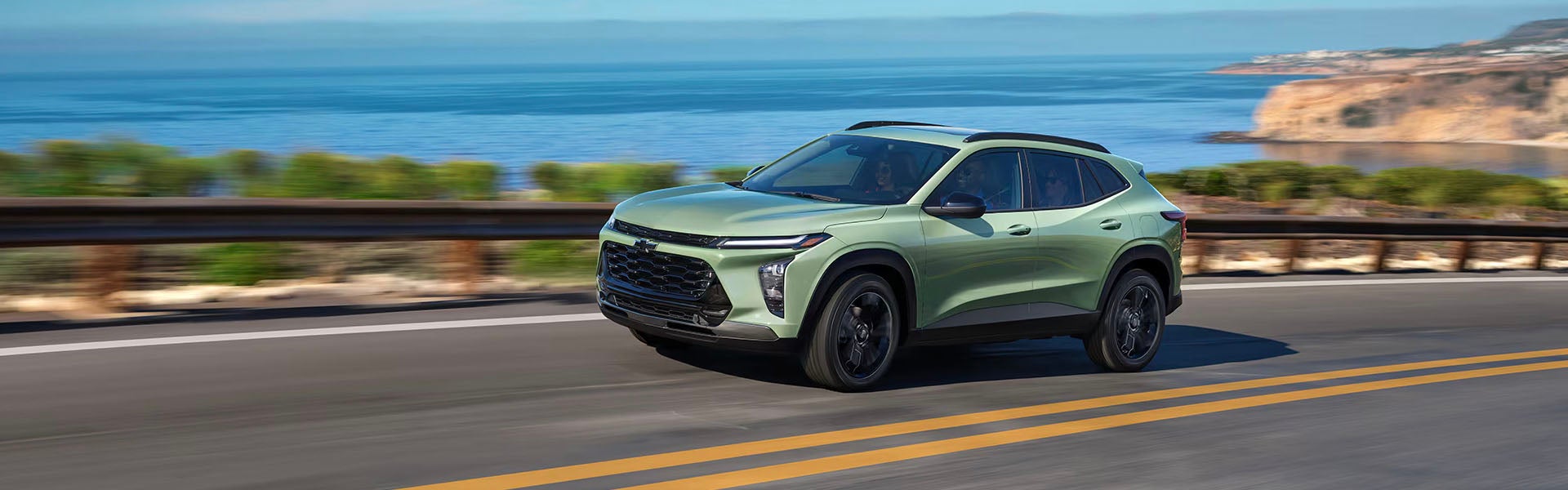 A green suv driving on the street.