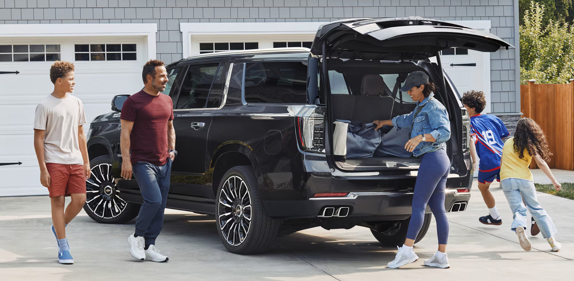 A family getting into the trunk of a suv.