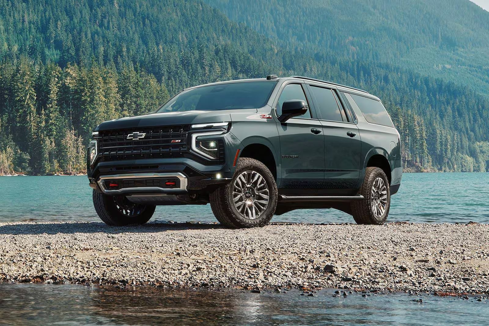 A green suv sitting by some water.