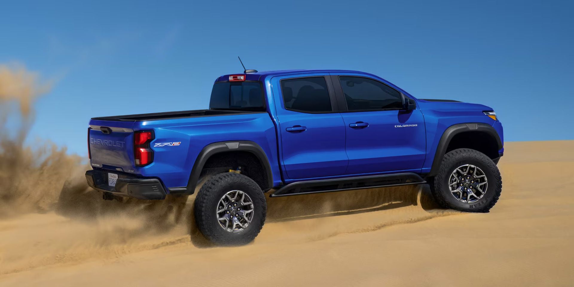 A blue truck driving off-road.