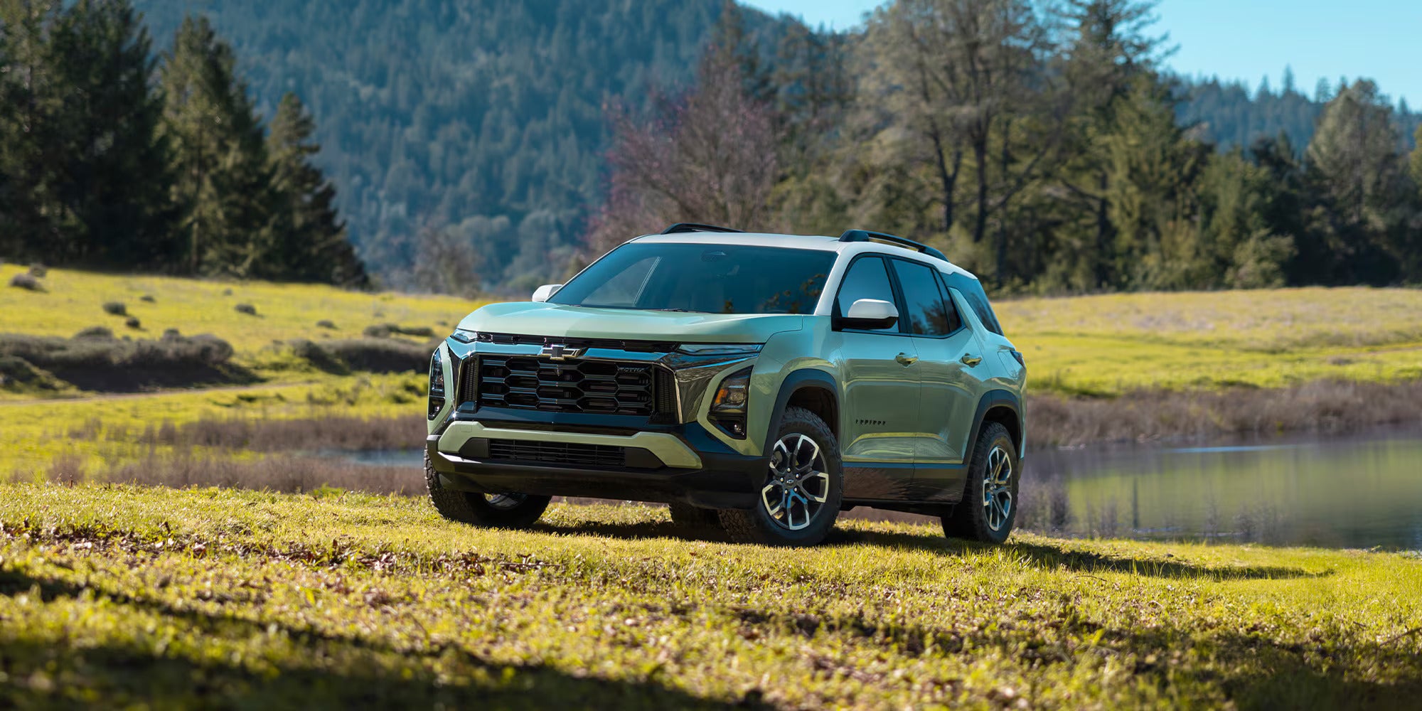 A green suv sitting parked in the grass.