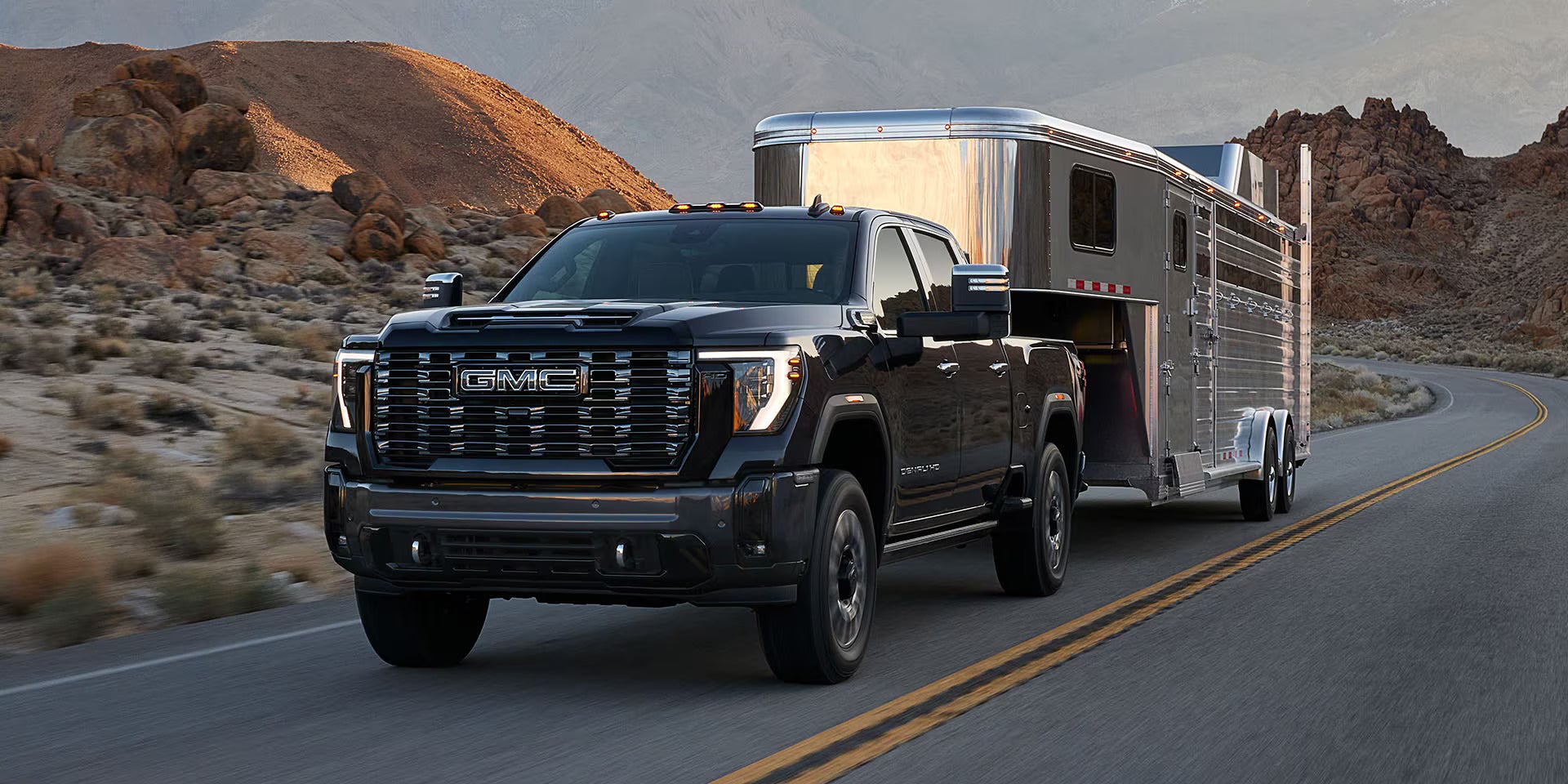 A black suv driving on the road with the trailer.