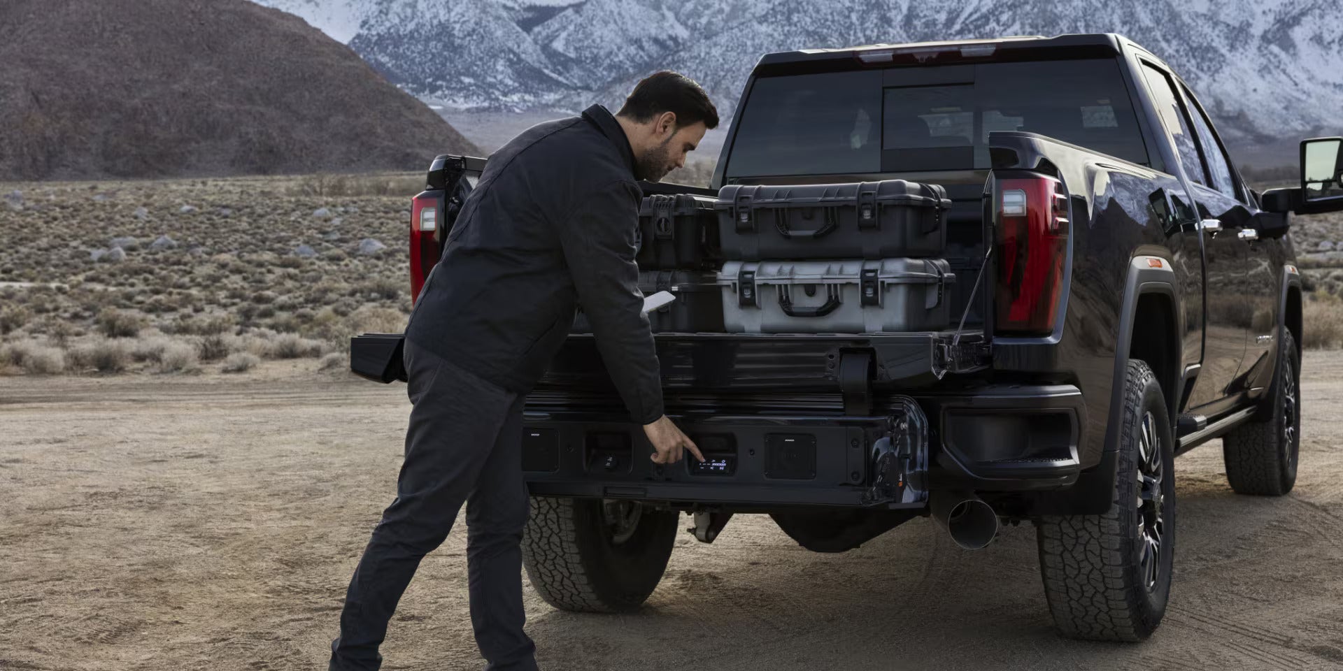 A man getting into the bed pf a truck.