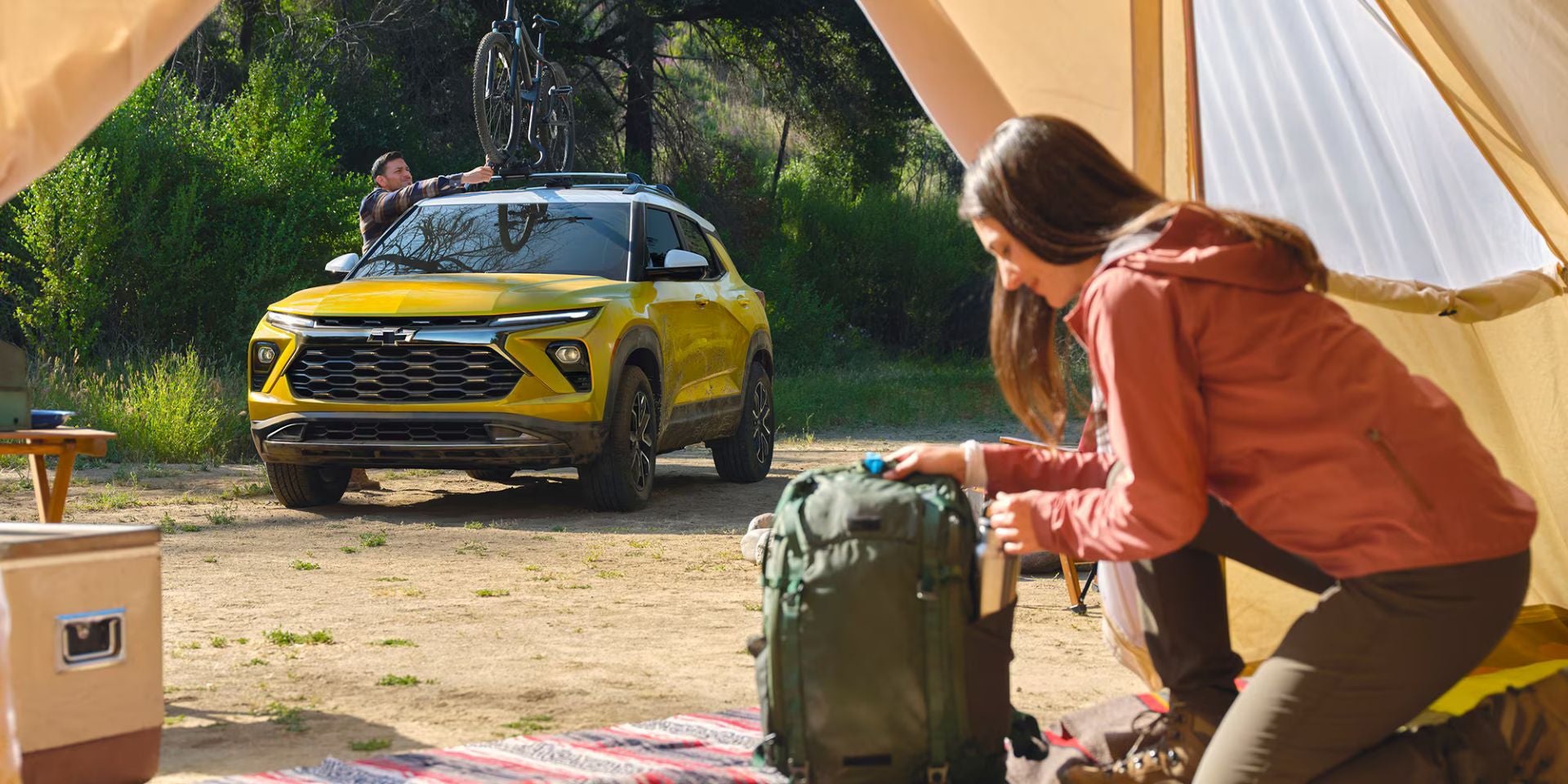 A man putting bike on the roof of a car.