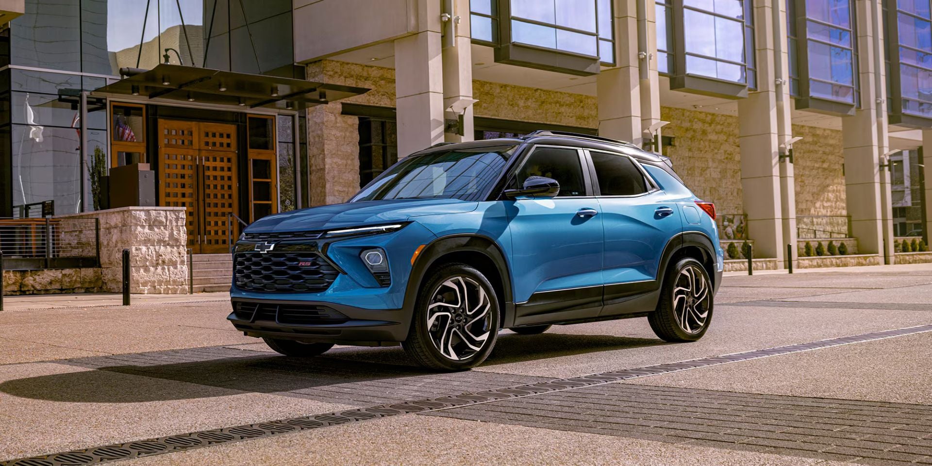 A blue suv sitting on the side of the road.