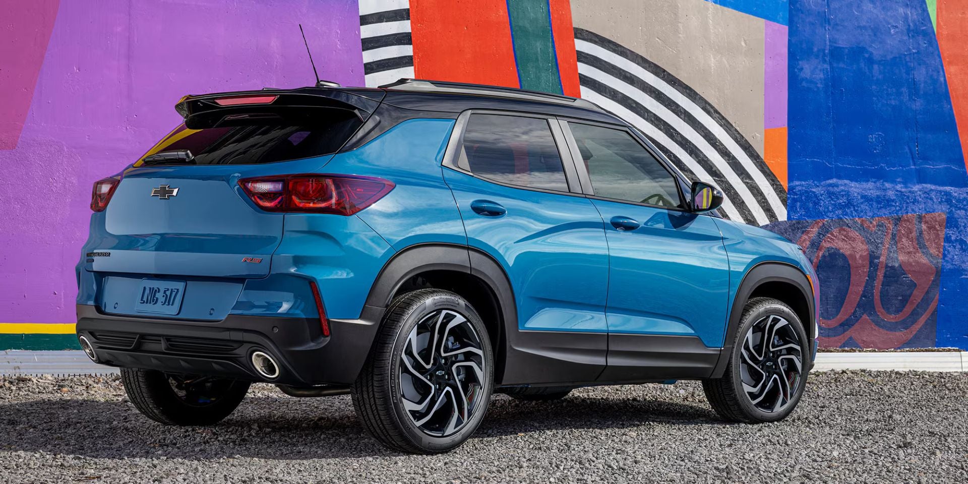 A blue siv sitting in the road.