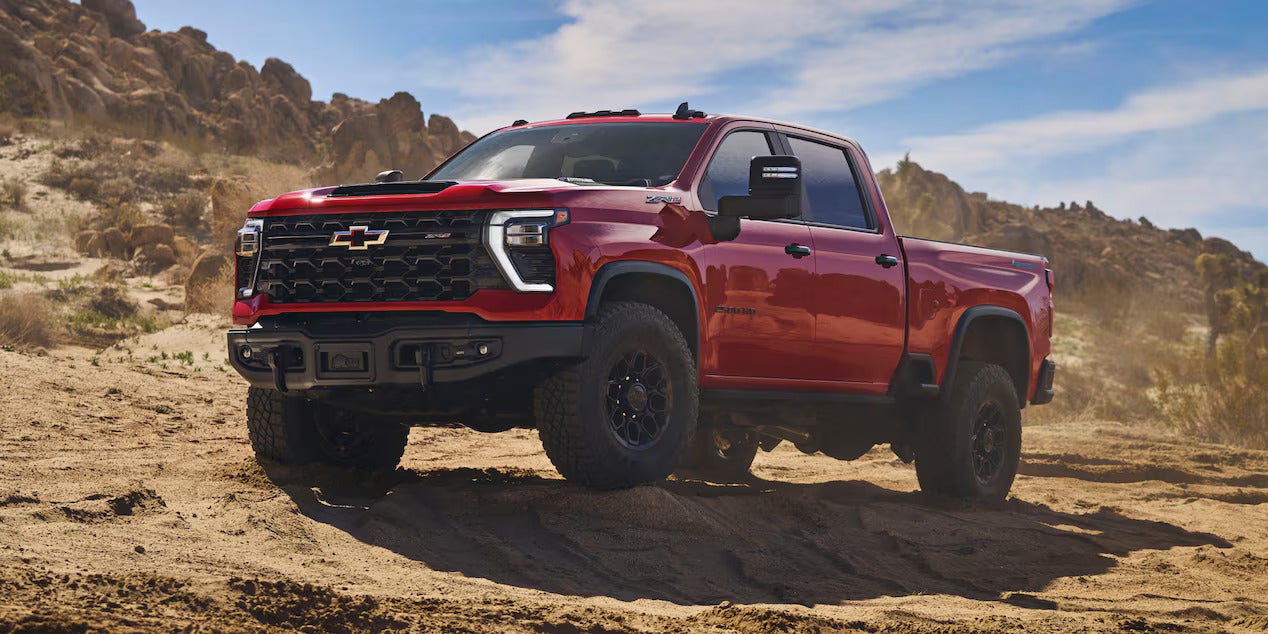 A red truck sitting on a dirt path.