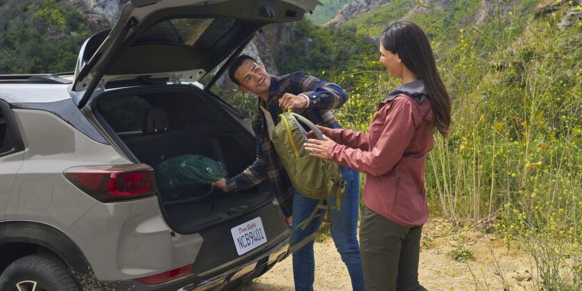 Two people getting into the trunk of trailblazer.