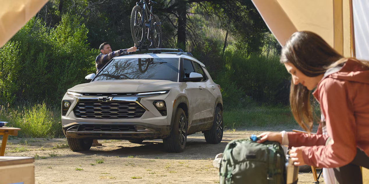 A man putting bikes un top of a trailblazer.