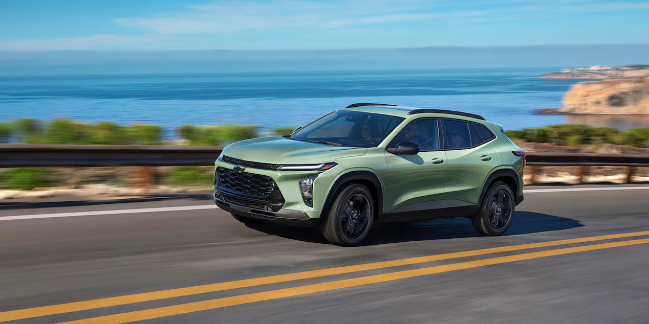 A green suv driving in the road.