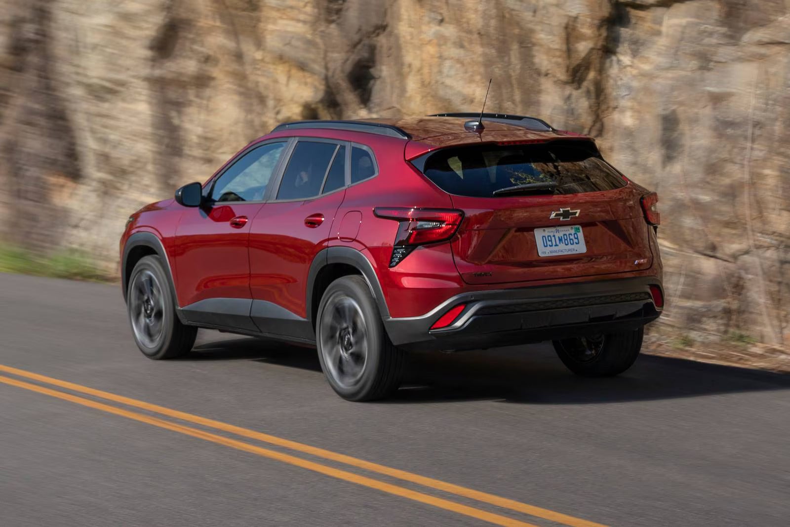 A red suv driving on the road.